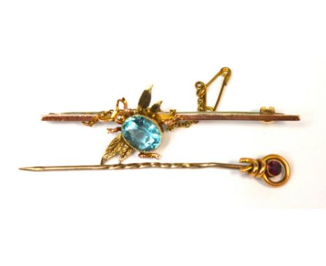 A yellow metal stick pin with a red stone finial and an Edwardian 9ct gold bar brooch with a bee to the centre, set with a bl