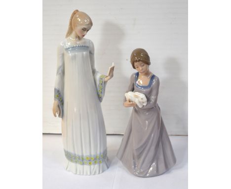 Two Nao figurines, one a young lady reading a book and one a young lady holding a rabbit.