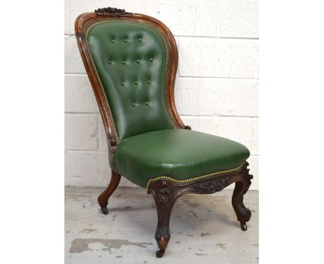 A Victorian carved walnut spoon back nursing chair, a carved top rail above upholstered seat and back to cabriole legs.