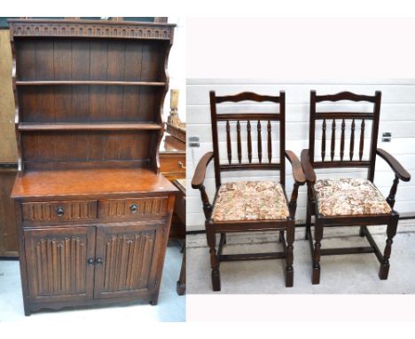 A 20th style oak Jacobean style dresser, frieze carved over two shelves, two drawers and two lower cupboard drawers and a pai