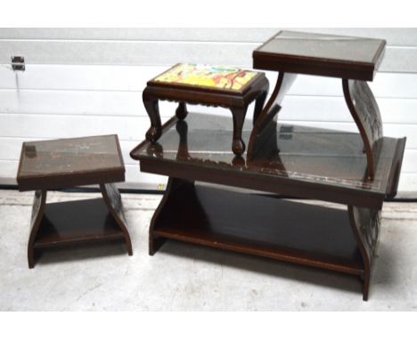 Three Oriental carved glass toped tables on curving solid legs to the base, carved with figures, trees and pagodas, largest 9