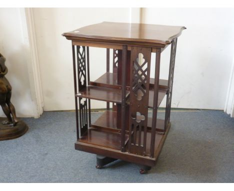 A late 19th Century revolving bookcase, in mahogany, having shaped top, with pierced sides, on ceramic castors, 56 cm x 56 cm
