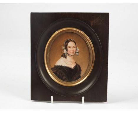A miniature portrait painting with indistinct signature to the right hand side near where the miniature meets the ebonised fr