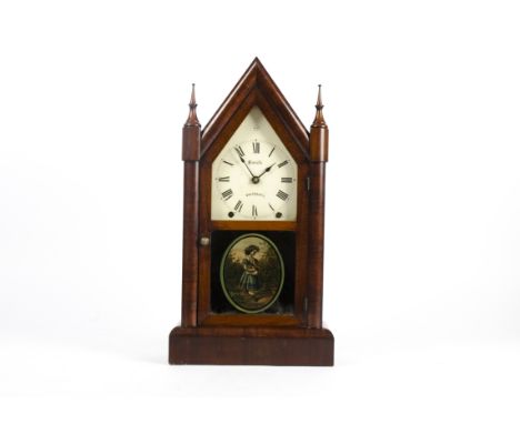 A Victorian American eight day mantle clock of Gothic architectural form, the mahogany case with a door with black glass glaz