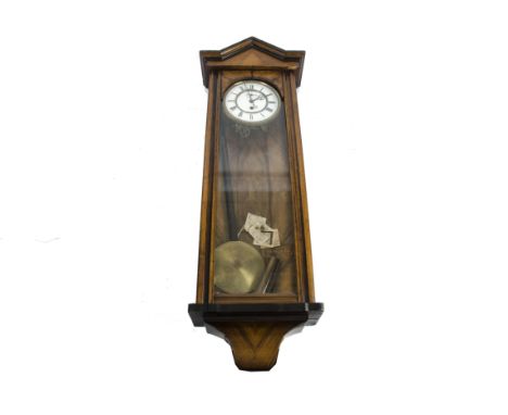 An early 20th Century wall clock, the mahogany architectural style case has a full length glazed hinged door with matching gl