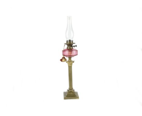 A cranberry glass oil lamp on attractive Corinthian brass column, Edwardian or first quarter of the 20th Century with "Best D