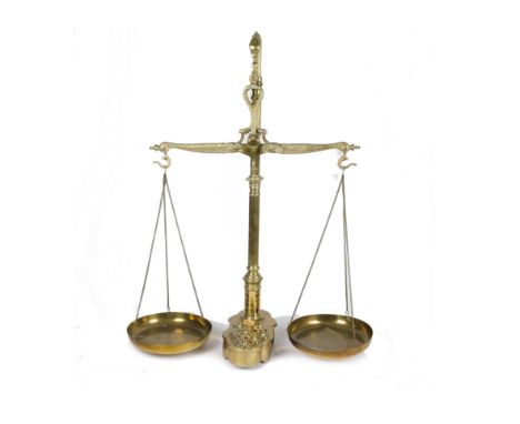 A 19th Century style set of beam scales having nine weights the whole raised on a shaped base, surmounted by a serpent finial