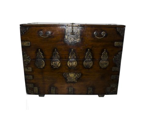 A 19th Century Chinese fruitwood and metal mounted travelling trunk, with brass carrying handles to the sides, the oblong top