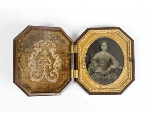 A 19th Century bakelite union case with ambrotype depicting a young lady seated, length 8.3 cm, the case has a velvet interio