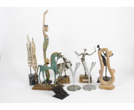 A collection of artistic figures depicting individuals dancing and skiing, comprising metal, ceramic, stone and wooden exampl