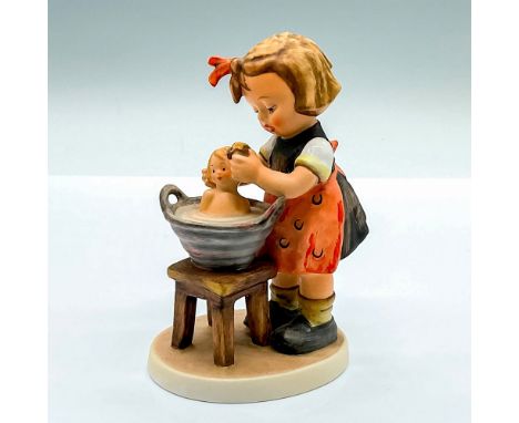 Hand painted figure of a young girl bathing her doll. Goebel Hummel backstamp. Issued: c. 1979-1990Dimensions: 3.5"L x 2.5"W 