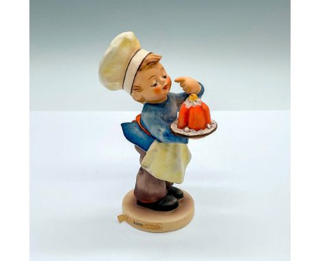 Hand painted figure of a young boy holding an orange cake. Goebel Hummel backstamp. Issued: c. 1979-1990Dimensions: 3"L x 2"W