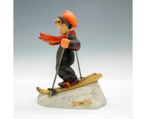 Boy in red and black winter outfit riding skis. Metal ski poles included. Hummel inscribed on base. Goebel backstamp. Issued: