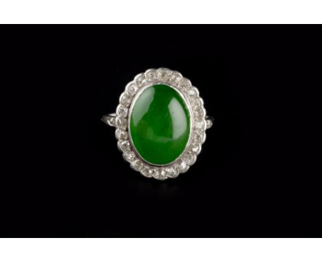 A JADE AND DIAMOND CLUSTER RING, the oval cabochon jade collet set within a border of cushion-shaped old-cut diamonds, above 