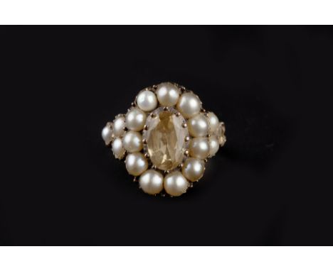 A YELLOW TOPAZ AND HALF PEARL CLUSTER RING, the oval mixed-cut yellow topaz in foiled closed-back setting, bordered by half p