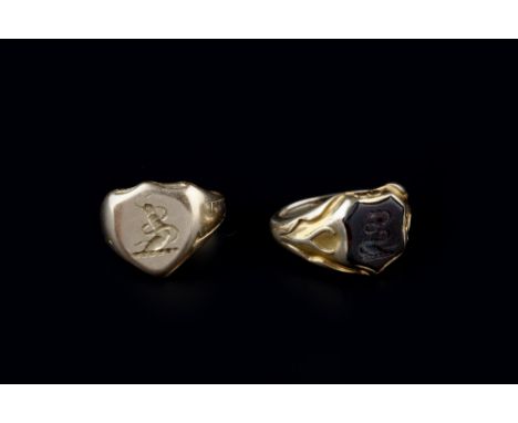 TWO SIGNET RINGS, the first inset with a shield-shaped bloodstone intaglio depicting the crest of a clenched arm and serpent,