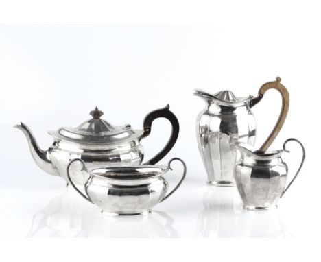 A SILVER FOUR PIECE TEA SERVICE, of faceted oval design by Barker Bros Ltd, comprising teapot with ebonised handle, Birmingha