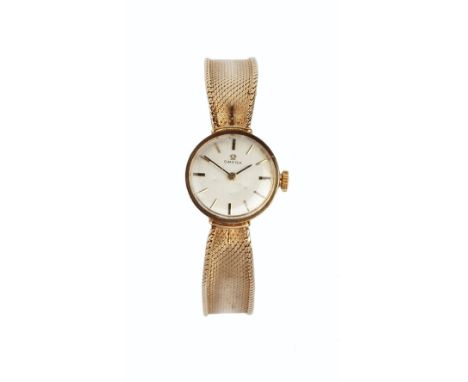 A LADY'S 9CT GOLD BRACELET WATCH BY OMEGA, the circular signed silvered dial with baton markers, to a fluted mesh-link bracel
