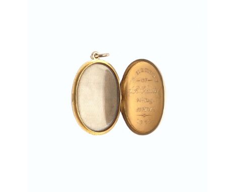 A VICTORIAN MEMORIAL LOCKET PENDANT ON CHAIN, the plain polished oval locket with interior glazed compartment and inscription