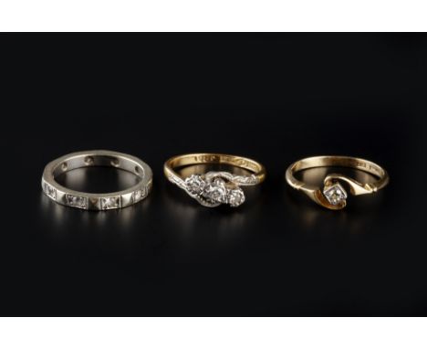 THREE GEM SET RINGS, comprising a diamond three stone crossover ring, the Swiss and single-cut diamonds in illusion setting, 