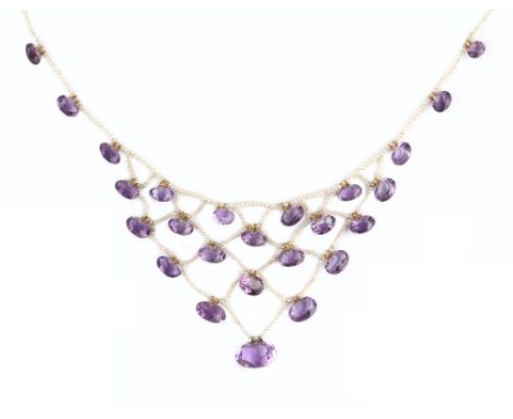 A LATE 19TH/EARLY 20TH CENTURY AMETHYST AND SEED PEARL BIB NECKLACE, the lattice-work seed pearl bib suspending rows of gradu
