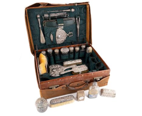 λ A late-Victorian silver dressing table set in a fitted travelling case,by Drew &amp; Sons, London 1899,embossed chased scro