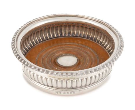 A George III silver wine coaster,by John W Story, London 1808,circular form with part-fluted decoration, on a turned wooden b