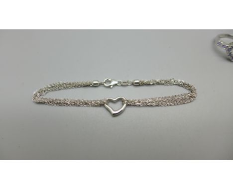 A 9ct white gold heart shaped ring set with purple stones and a 9ct white gold bracelet with heart detail, total weight 4.9g,