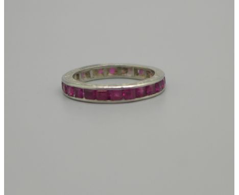 A white metal eternity ring set with rubies, a/f, 3.6g, N, tests as platinum 