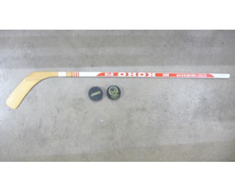 A signed Koho ice hockey stick with two pucks 