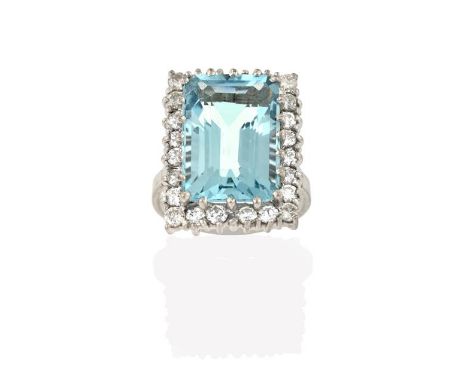 An Aquamarine and Diamond Cluster Ring, the emerald-cut aquamarine within a border of round brilliant cut diamonds, in white 