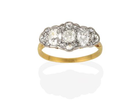 A Diamond Cluster Ring, an old cut diamond flanked by oval cut diamonds, within a border of old cut and rose cut diamonds, in