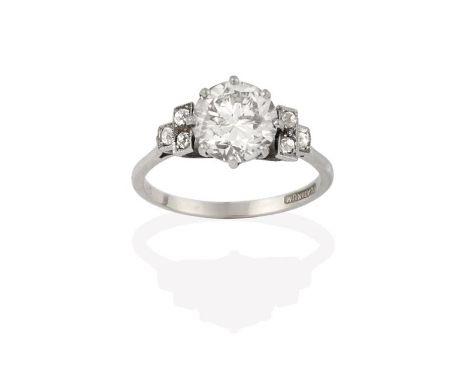 A Diamond Solitaire Ring, the round brilliant cut diamond to old cut diamond set stepped shoulders, in white claw and millegr