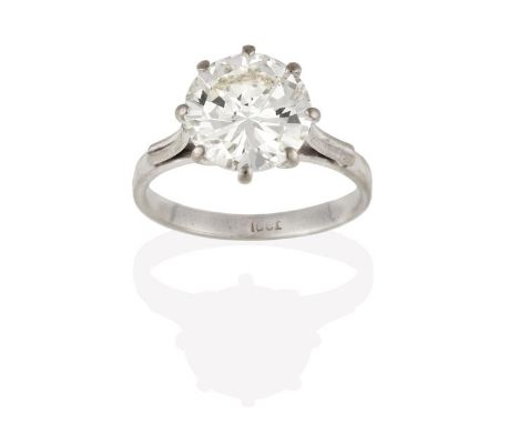 A Diamond Solitaire Ring, the round brilliant cut diamond in a white claw setting, to a tapered shoulder plain polished shank