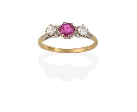 A Pink Sapphire and Diamond Three Stone Ring, the central round cut pink sapphire flanked by round brilliant cut diamonds, in