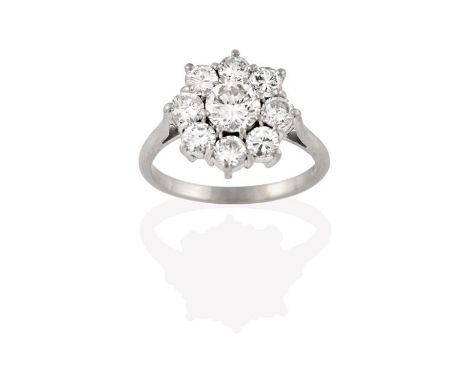 A Diamond Cluster Ring, the central round brilliant diamond within a border of smaller round brilliant cut diamonds, in white