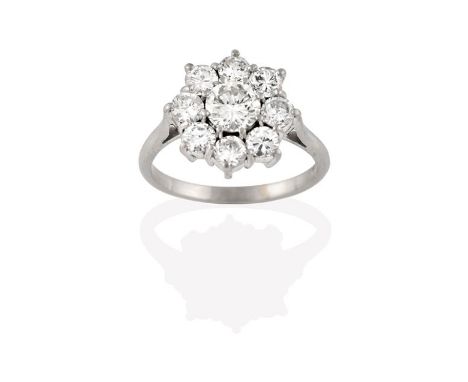 A Diamond Cluster Ring, the central round brilliant diamond within a border of smaller round brilliant cut diamonds, in white