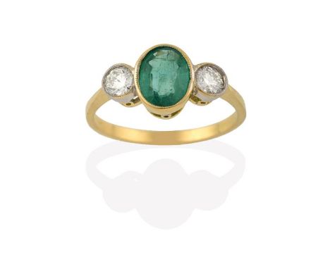 An Emerald and Diamond Three Stone Ring, the oval cut emerald in a yellow millegrain setting, flanked by round brilliant cut 