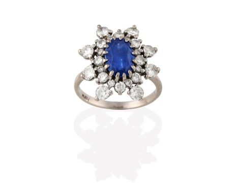 A Sapphire and Diamond Cluster Ring, the oval cut sapphire within a double border of round brilliant cut diamonds, in white c