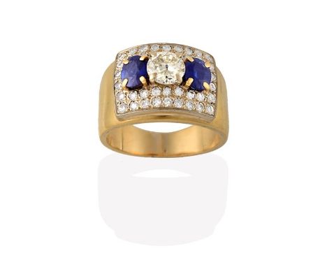 A Sapphire and Diamond Ring, a round brilliant cut diamond in white claw settings, flanked by two round brilliant cut sapphir