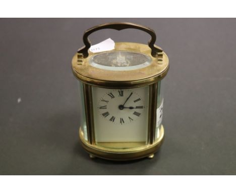 French Brass Carriage clock with an oval form and enamel dial