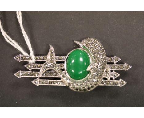 A silver marcasite and jade brooch in the form of a dolphin