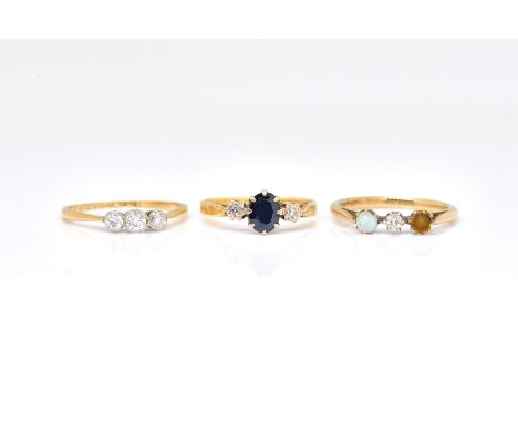 A GOLD AND DIAMOND THREE STONE RING AND TWO FURTHER RINGS (3)The diamond ring mounted with a row of three cushion shaped diam