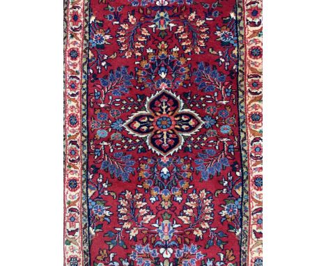 SAROUGH RUNNER, PERSIANThe madder field with a central medallion, all with abundantly floral sprays; an ivory floral border 2