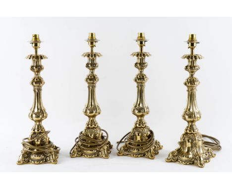 FOUR BRASS TABLE LAMP BASES (4)Each with tapering column stems, globular socles and scrolling, shell capped bases, 46 cm high