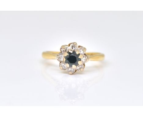 AN 18CT GOLD, SAPPHIRE AND DIAMOND CLUSTER RINGClaw set with the circular cut sapphire in a surround of eight circular cut di