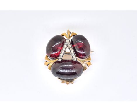 A CARBUNCLE GARNET AND DIAMOND INITIAL 'A' BROOCHLate 19th century, set with three oval cabochon carbuncle garnets, in a tref