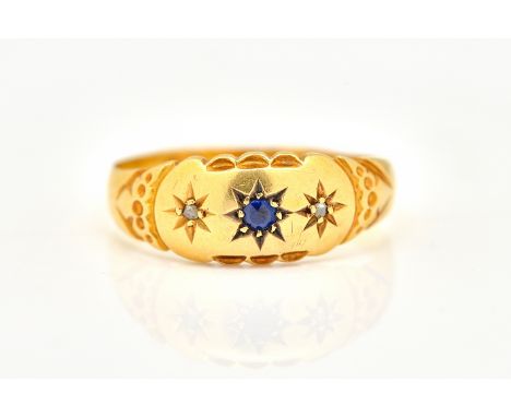 AN 18CT GOLD, DIAMOND AND BLUE GEM SET THREE STONE RINGStar gypsy set with a central blue gem, between two small diamonds, Ch