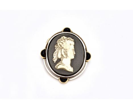 A FRENCH GOLD MOUNTED CAMEO BROOCHSet with an oval ceramic carved portrait cameo within a white enamel and red cabochon set b