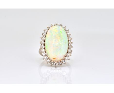 A WHITE GOLD, OPAL AND DIAMOND OVAL CLUSTER RINGClaw set with the oval opal within a surround of circular cut diamonds, detai